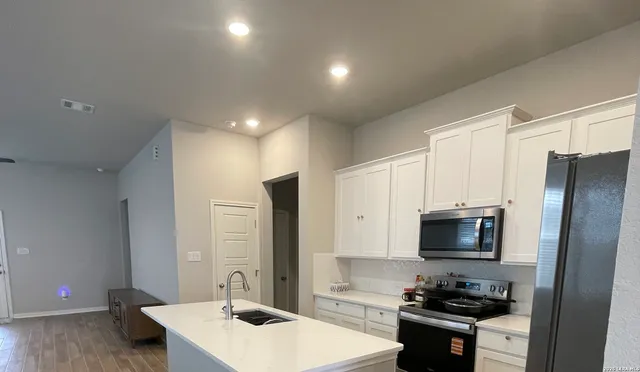 a kitchen with stainless steel appliances a stove microwave and refrigerator