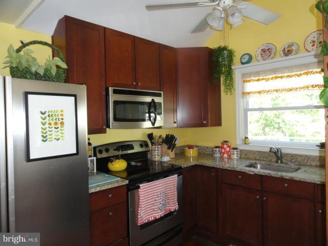 403 Paradise Road Riva, MD 21140 - Photo 9 of 22 a kitchen with stainless steel appliances granite countertop a sink dishwasher a stove a microwave oven with granite countertops and cabinets