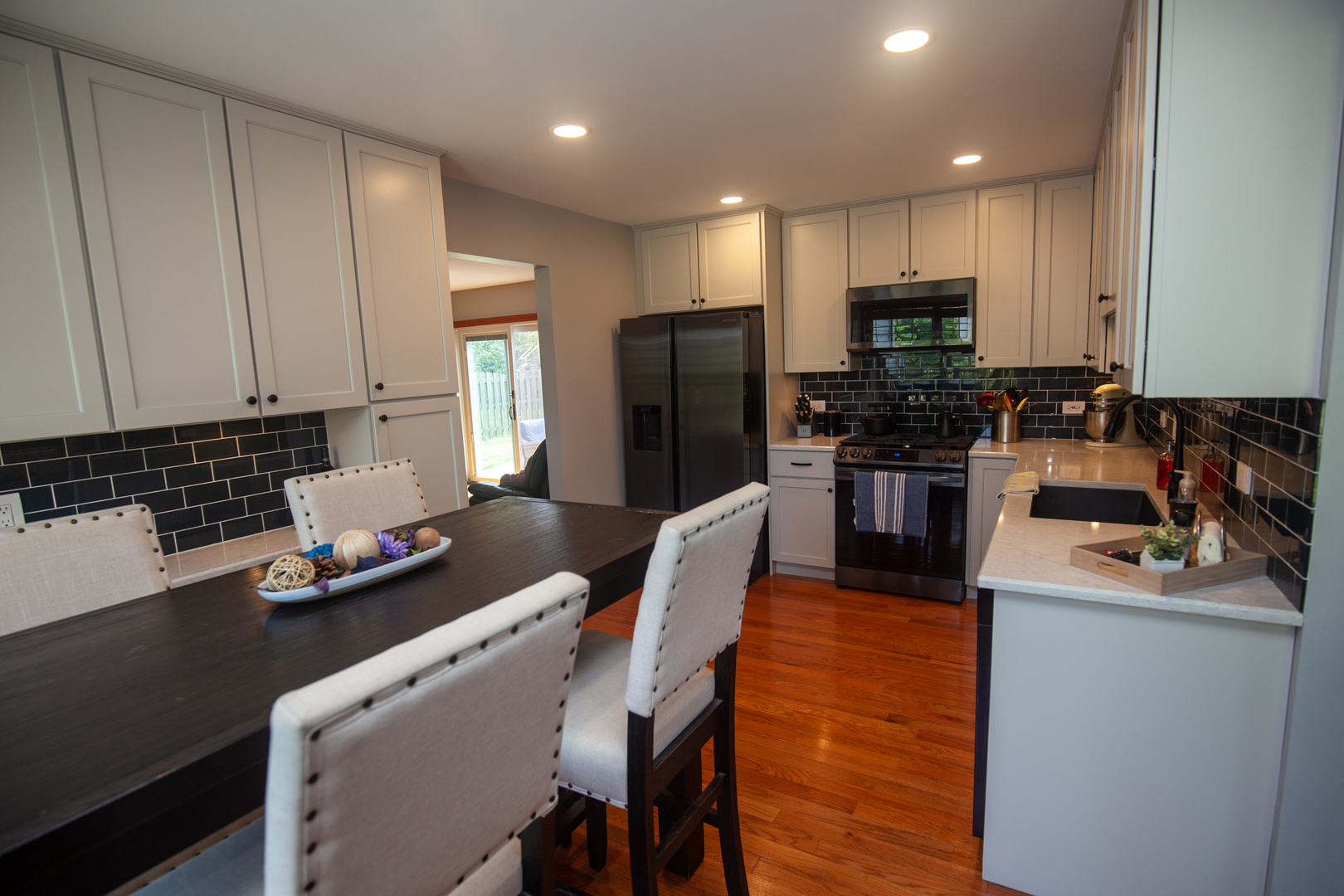 613 Cartwright Trail McHenry, IL 60050 - Photo 4 of 23 a kitchen with stainless steel appliances a stove a sink a refrigerator white cabinets and wooden floor