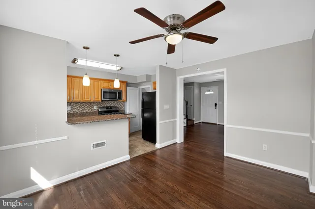 a kitchen with a refrigerator and a wooden floor