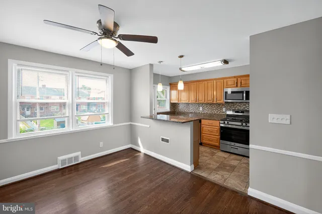 a kitchen with stainless steel appliances white cabinets and wooden floor