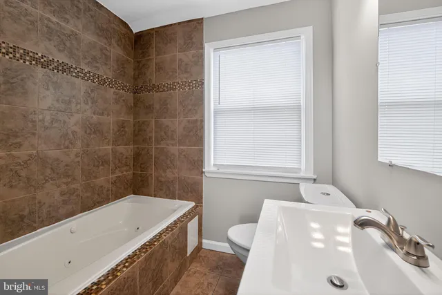 a bathroom with a tub a sink and a window