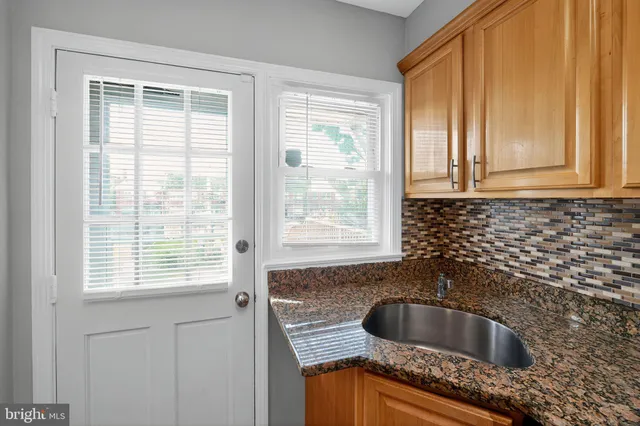 a kitchen with granite countertop a sink and a window
