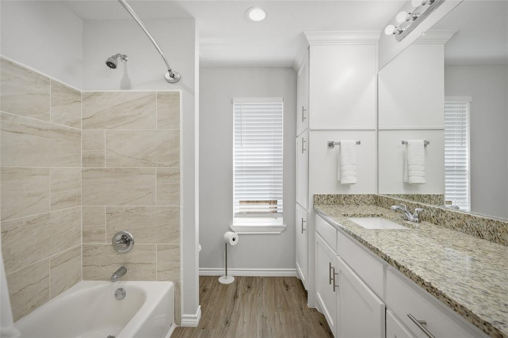 105 Thode Street Whitesboro, TX 76273 - Photo 18 of 28 a bathroom with a granite countertop sink a toilet and bathtub