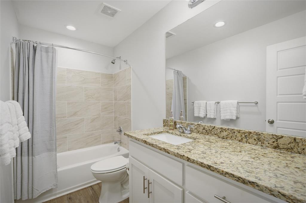 105 Thode Street Whitesboro, TX 76273 - Photo 20 of 28 a bathroom with a granite countertop sink toilet and shower