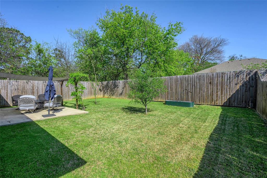 105 Thode Street Whitesboro, TX 76273 - Photo 5 of 28 a view of a backyard with a garden and entertaining space