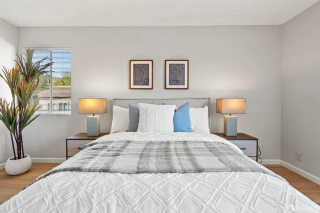 a bedroom with a bed and a lamp with potted plant