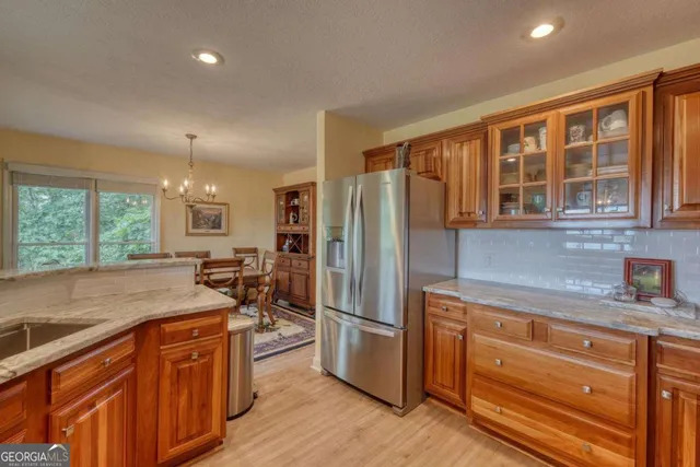 a kitchen with stainless steel appliances granite countertop a refrigerator a sink dishwasher stove and oven with wooden floor