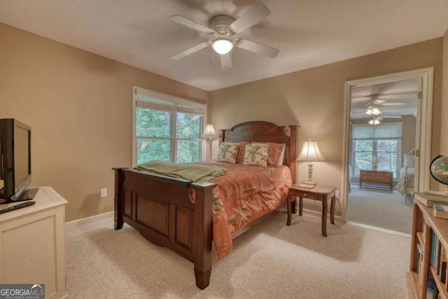 a bedroom with bed and window with chair