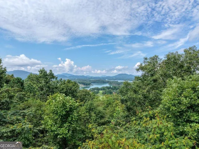 a kitchen with stainless steel appliances granite countertop wooden cabinets a sink dishwasher a stove and a refrigerator with wooden floor