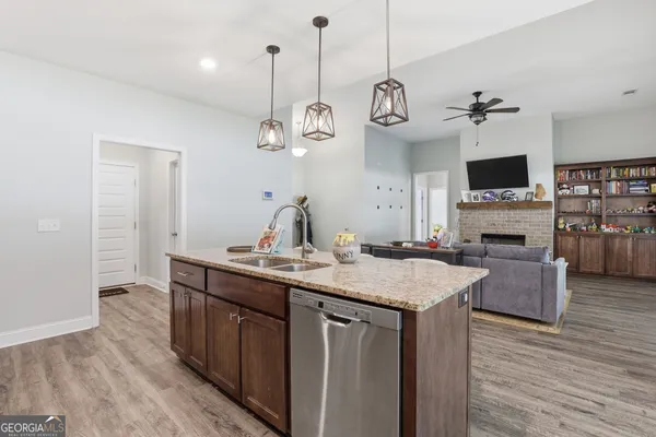 a room with kitchen island a wooden floor and a chandelier