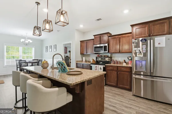a kitchen with kitchen island granite countertop a sink stainless steel appliances and cabinets