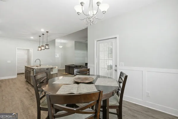 a view of a dining room with furniture wooden floor and a chandelier