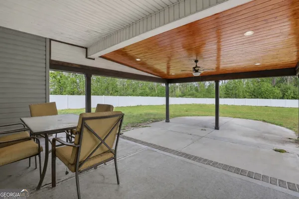 a view of a patio with a table and chairs under an umbrella