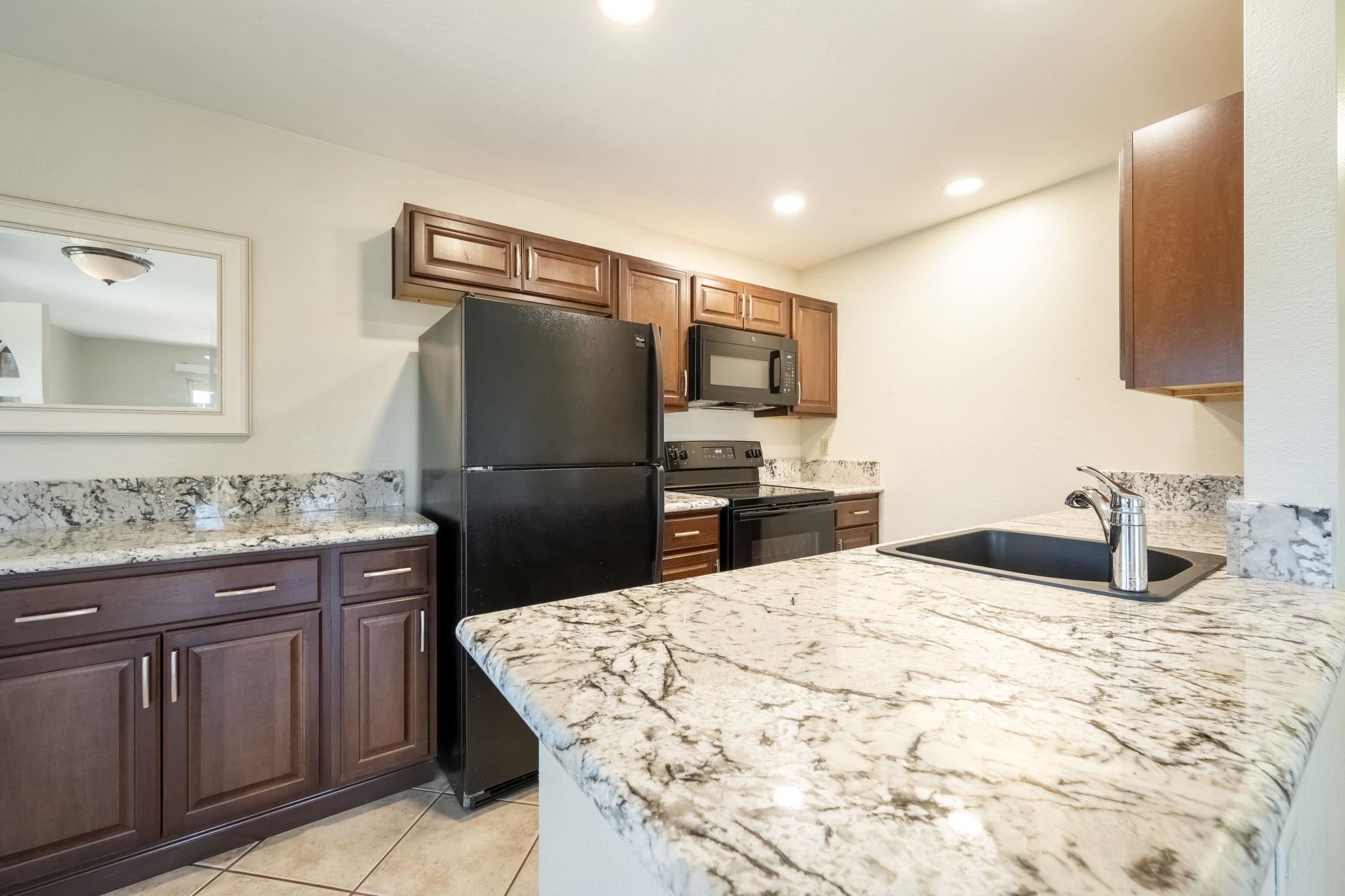 480 Kenolio Road, Unit 31205 Kihei, HI 96753 - Photo 11 of 45 a kitchen with a sink and refrigerator