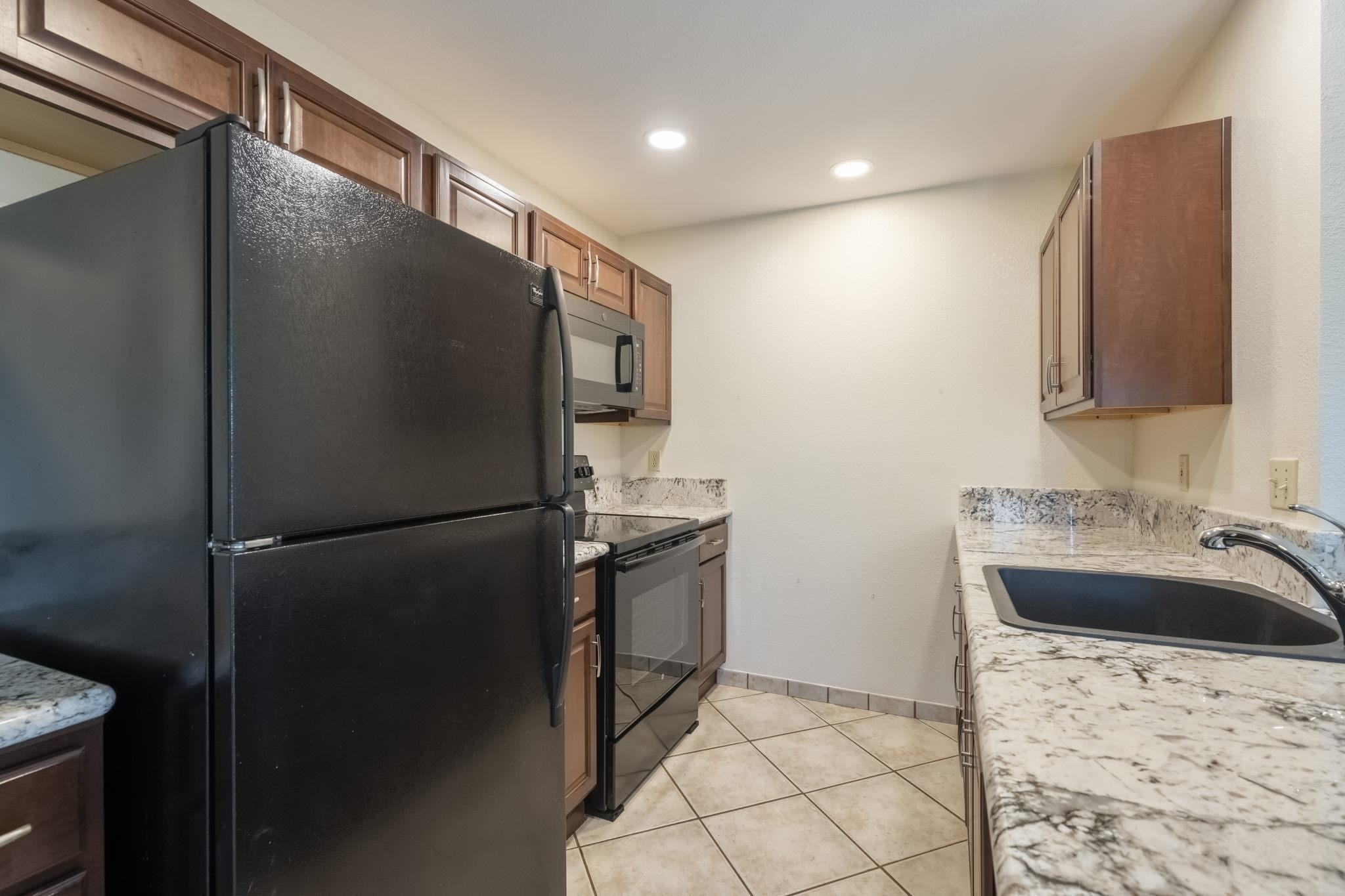 480 Kenolio Road, Unit 31205 Kihei, HI 96753 - Photo 12 of 45 a kitchen with a refrigerator and a sink