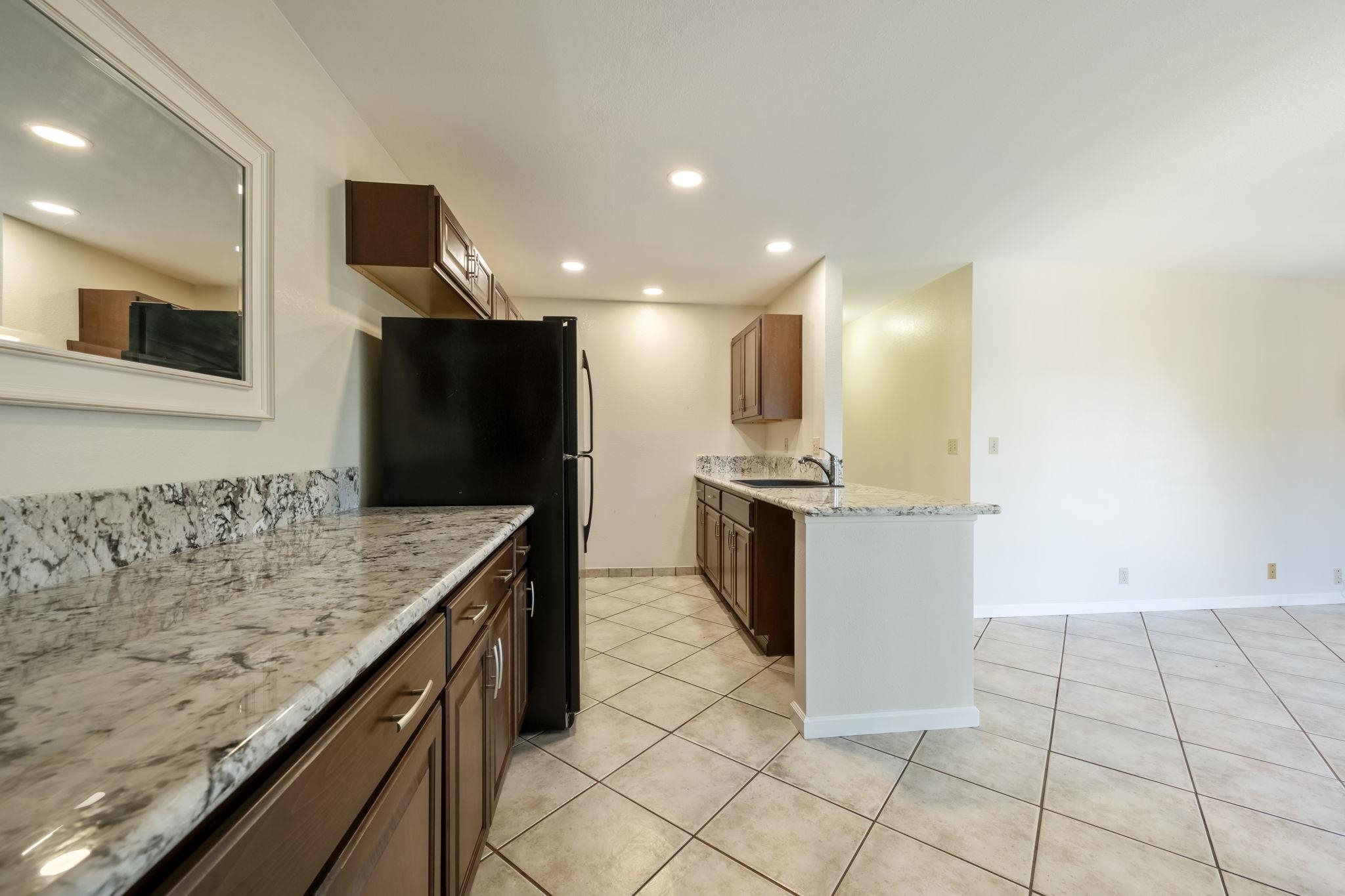 480 Kenolio Road, Unit 31205 Kihei, HI 96753 - Photo 16 of 45 a kitchen with stainless steel appliances kitchen island granite countertop a refrigerator and a sink