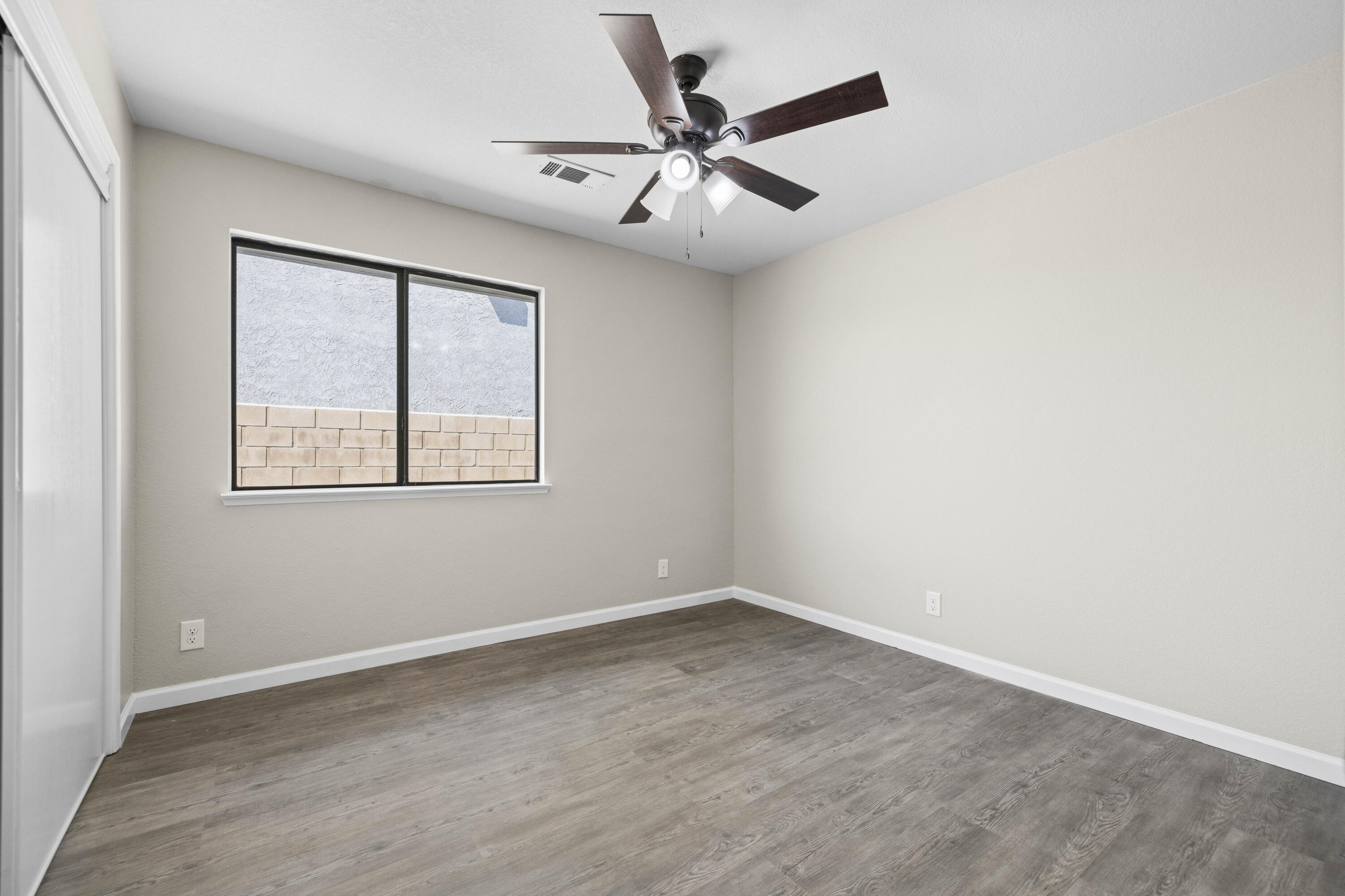 1270 Ave H4 Lancaster, CA 93534 - Photo 11 of 39 an empty room with wooden floor ceiling fan and windows