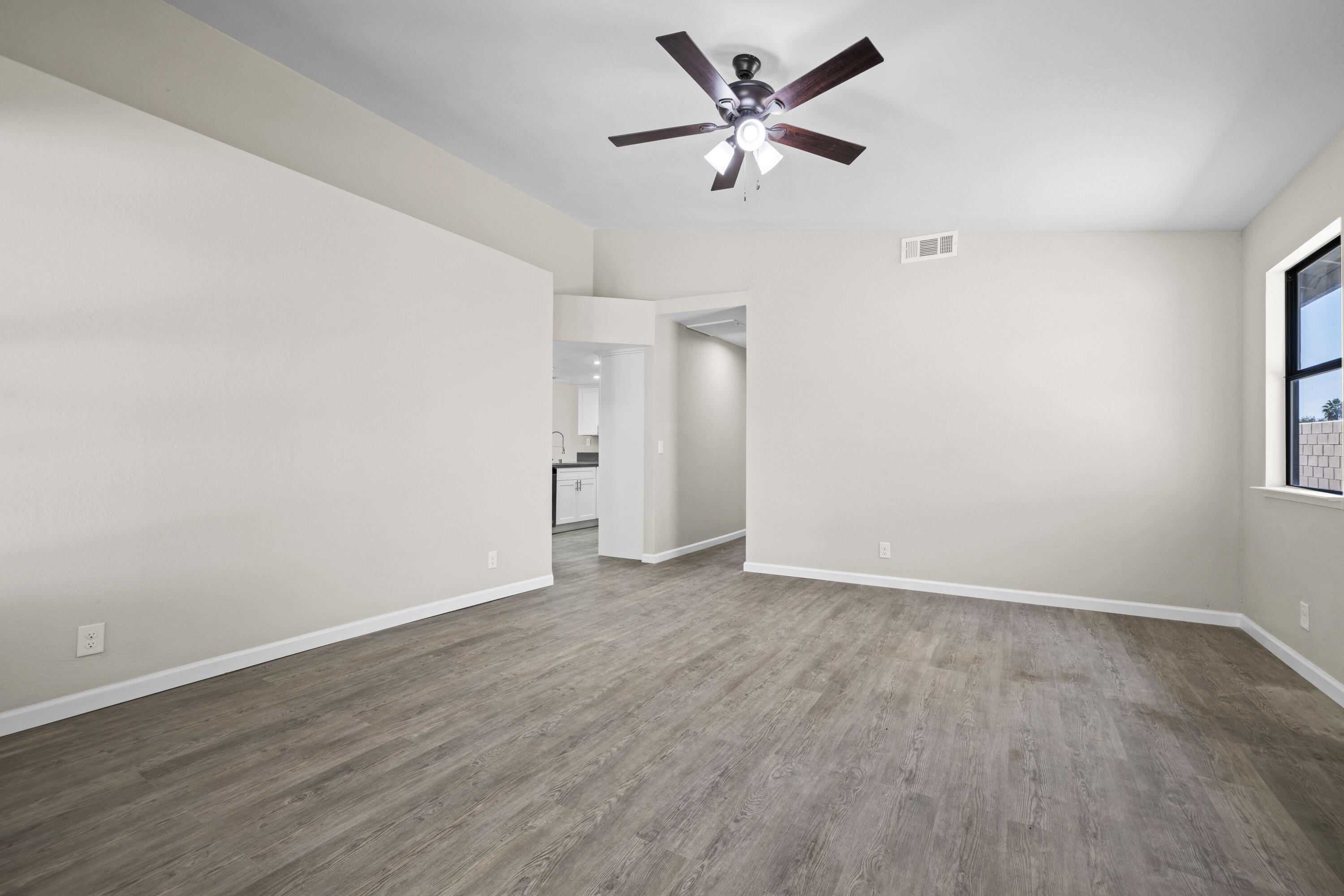 1270 Ave H4 Lancaster, CA 93534 - Photo 3 of 39 an empty room with wooden floor and a ceiling fan