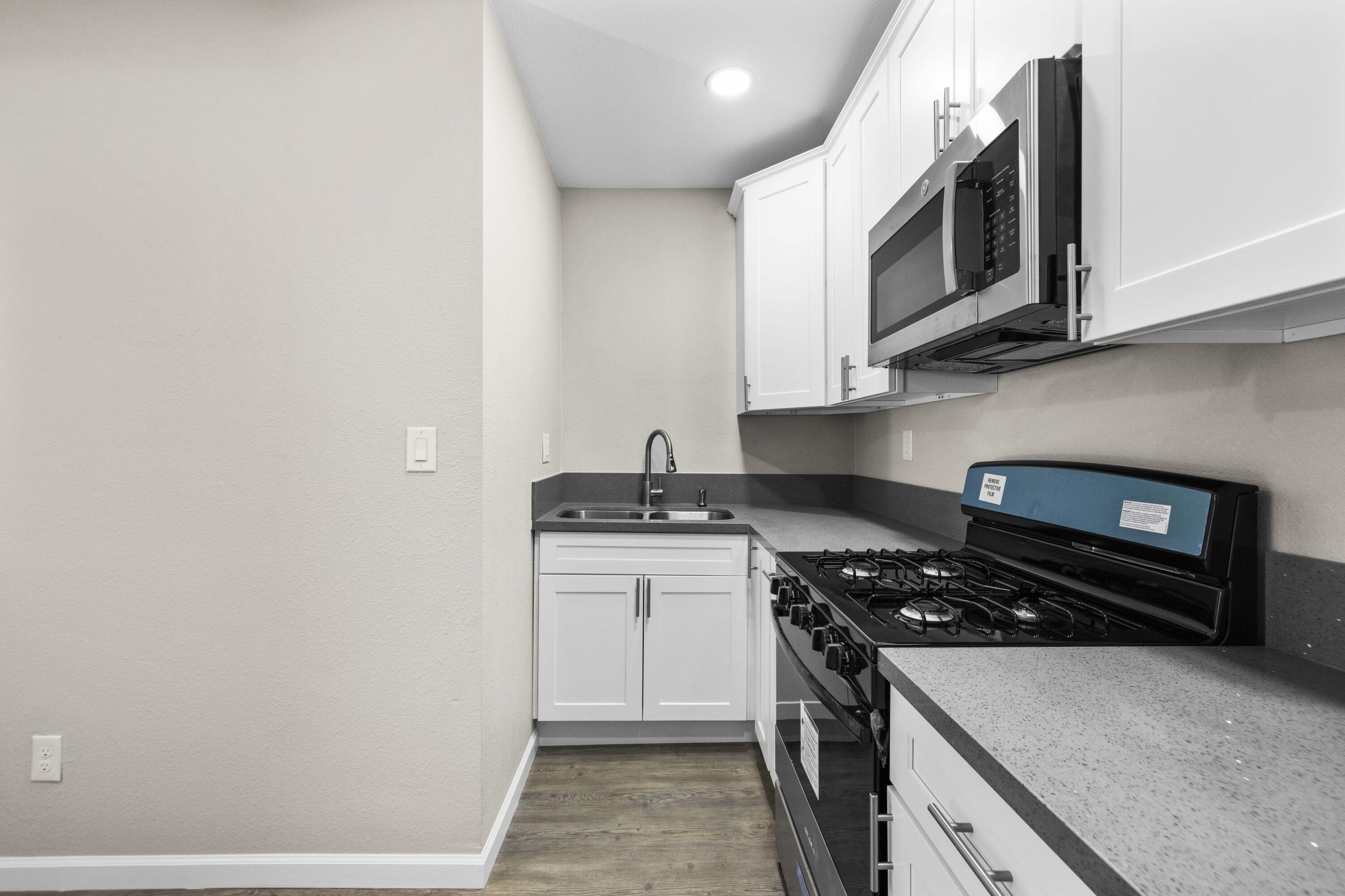 1270 Ave H4 Lancaster, CA 93534 - Photo 32 of 39 a kitchen with stainless steel appliances granite countertop a stove and a microwave
