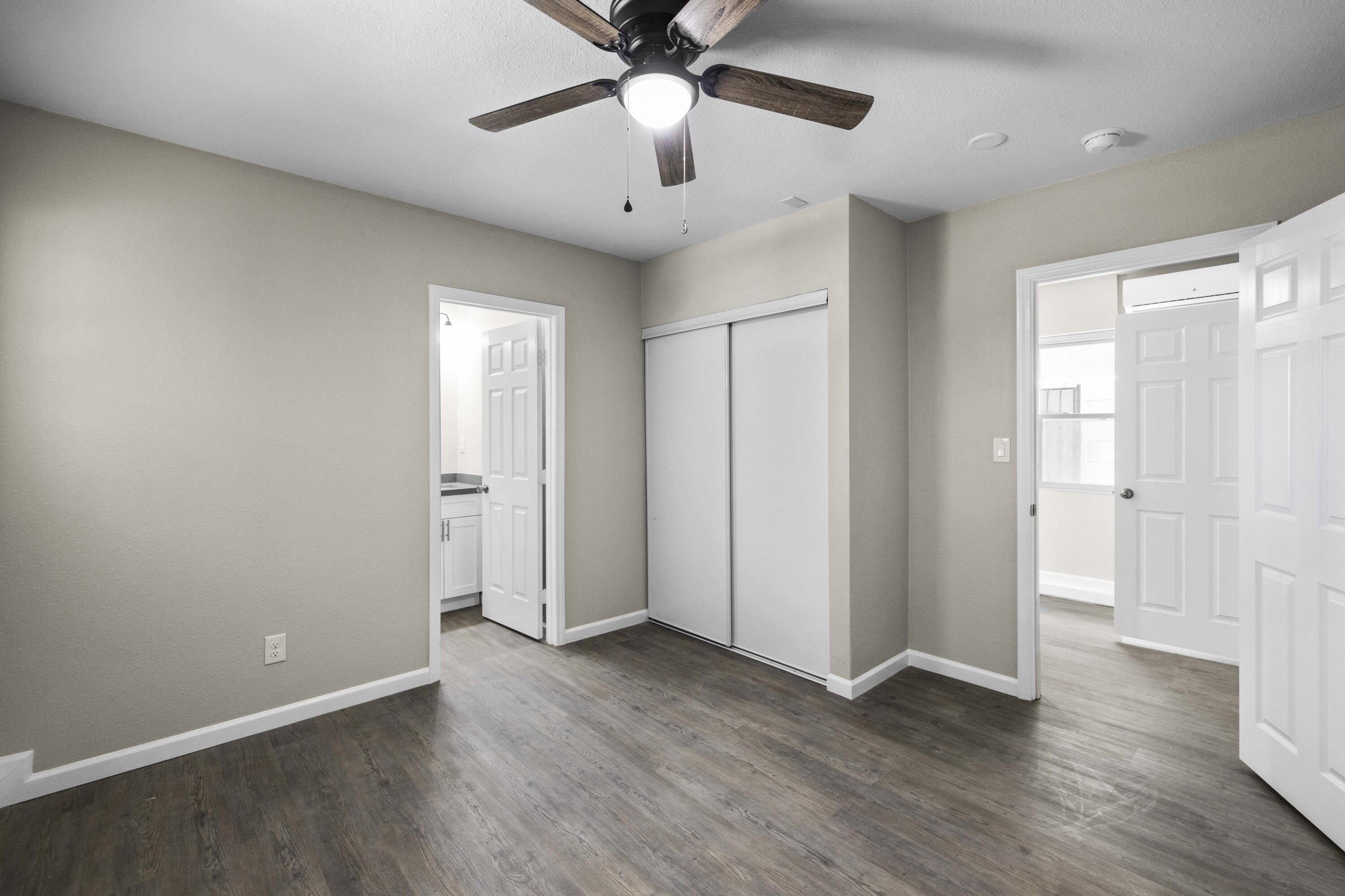 1270 Ave H4 Lancaster, CA 93534 - Photo 35 of 39 an empty room with wooden floor and a ceiling fan