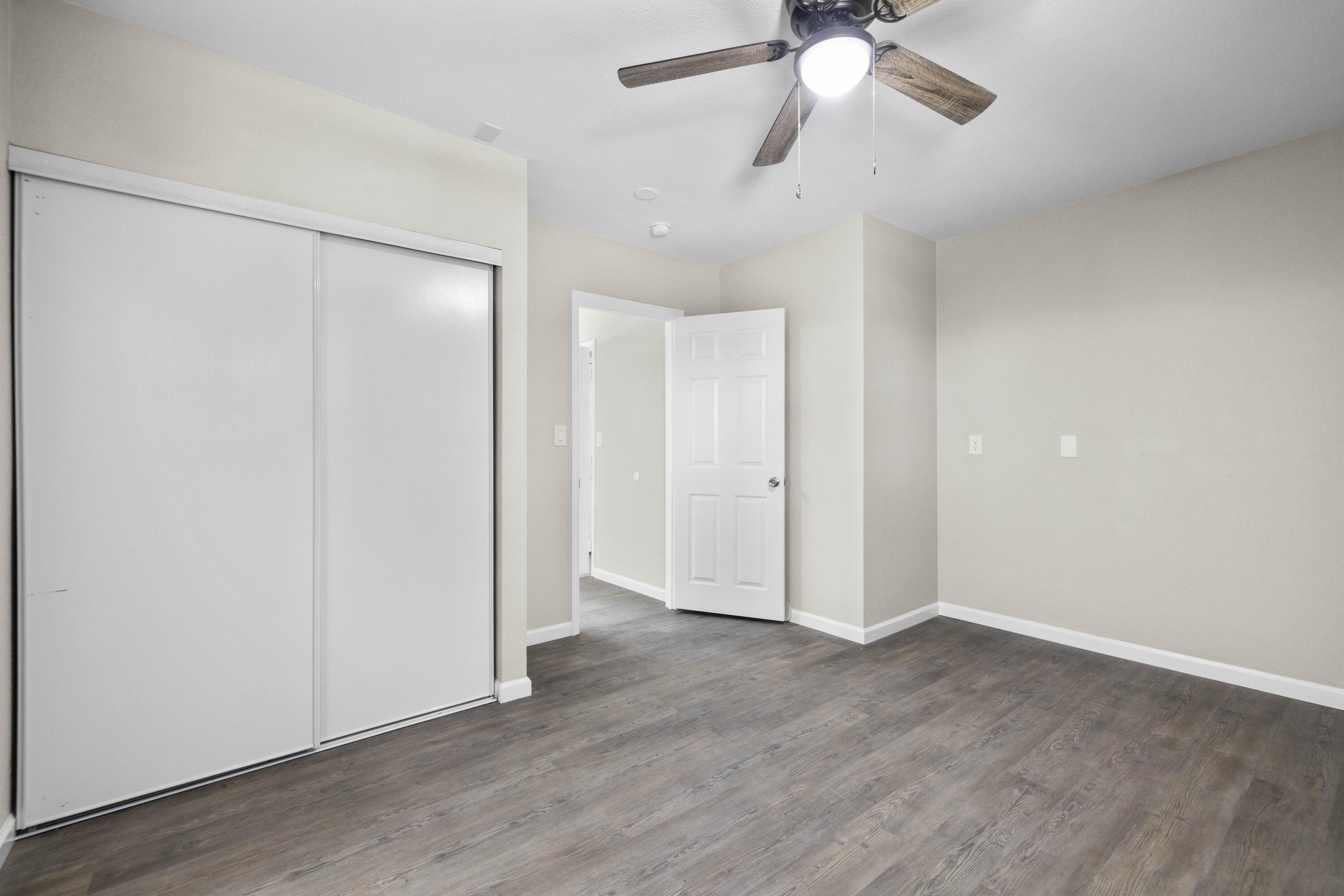 1270 Ave H4 Lancaster, CA 93534 - Photo 36 of 39 an empty room with wooden floor fan and windows