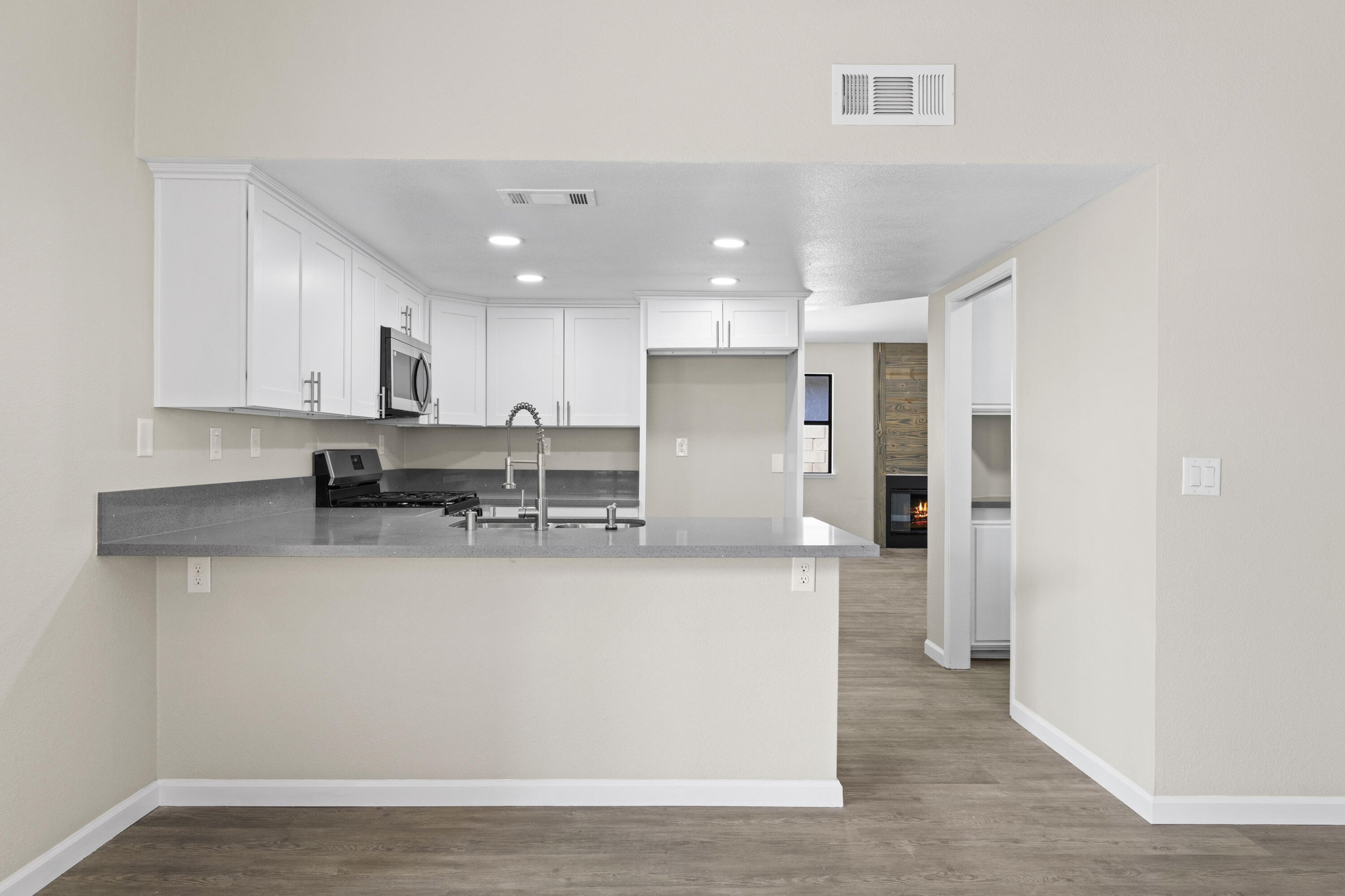 1270 Ave H4 Lancaster, CA 93534 - Photo 9 of 39 a large kitchen with stainless steel appliances a refrigerator a sink dishwasher a stove and white cabinets with wooden floor