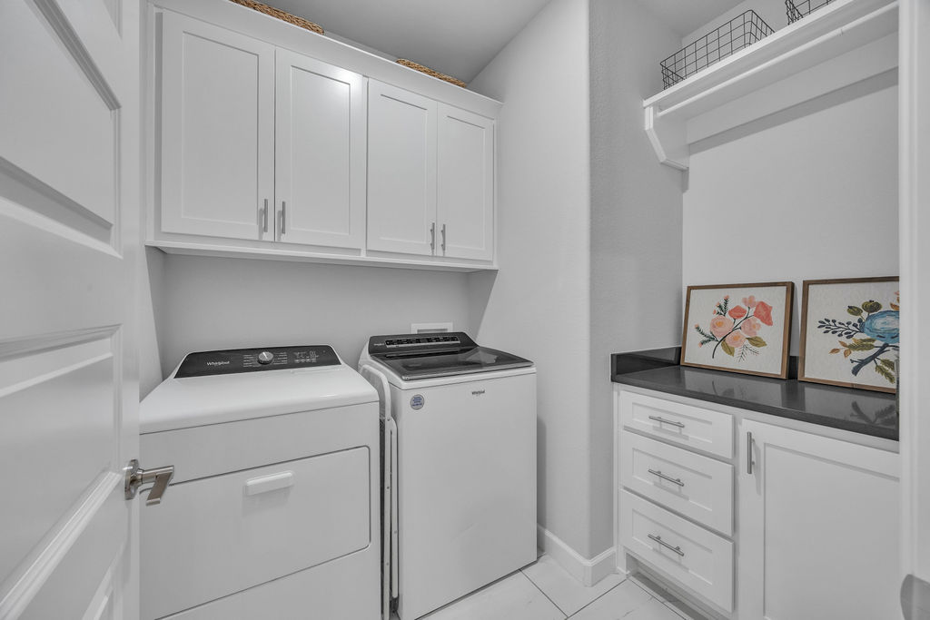 418 Casella Street Springdale, AR 72762 - Photo 26 of 34 White shaker-style cabinetry with silver hardware, dark stone-finish countertop, and tile flooring