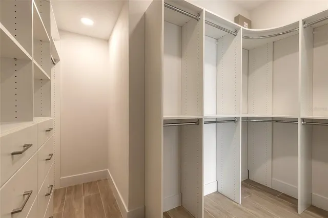a view of walk in closet with empty racks