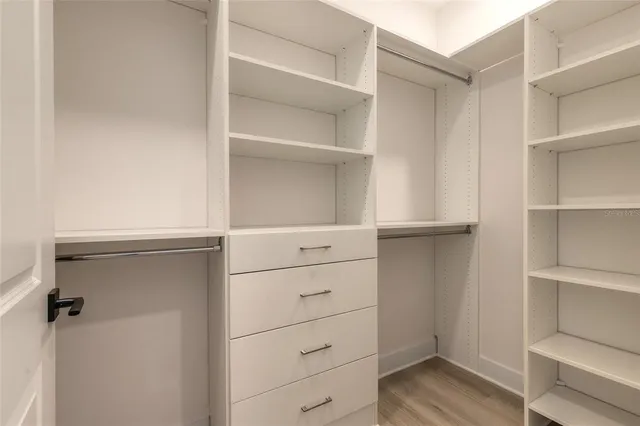 a view of walk in closet with empty racks