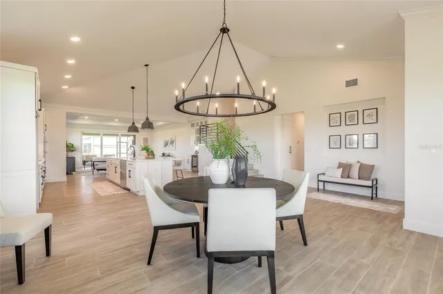 a dining room with wooden floor a glass table and chairs