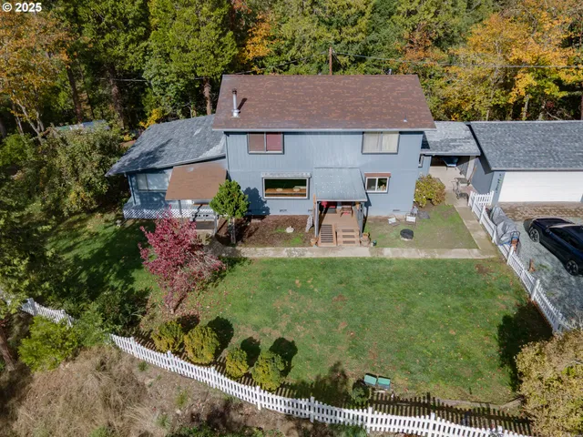 an aerial view of a house with swimming pool and trees