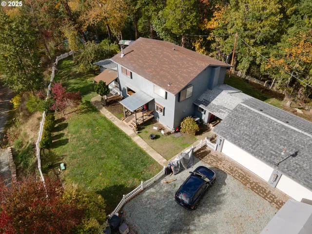 an aerial view of a house with a yard and a lot of lake