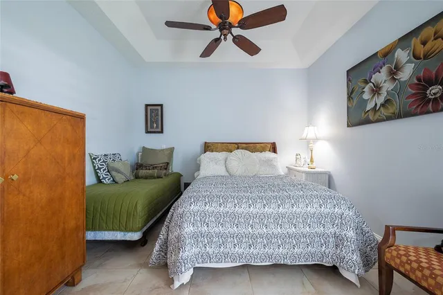 a bedroom with a bed a window and a lamp on a dresser