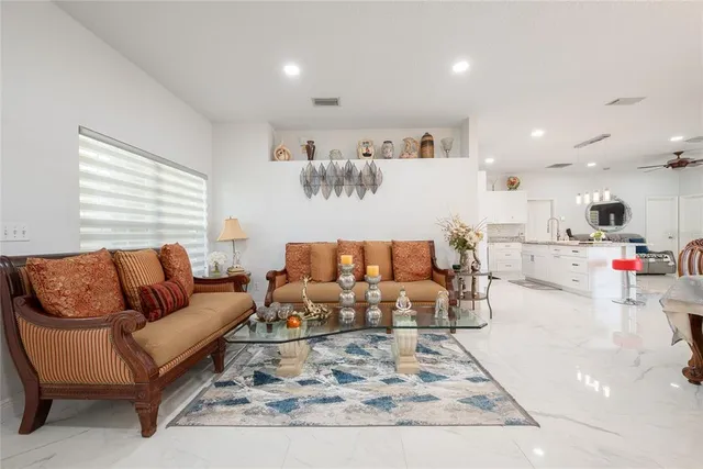 a living room with furniture and kitchen view