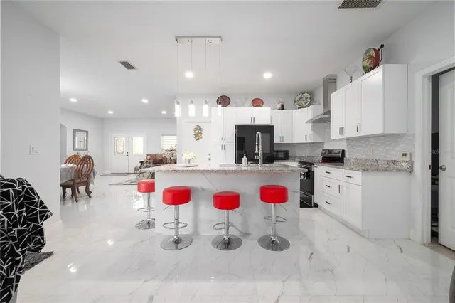 a kitchen with white cabinets and appliances