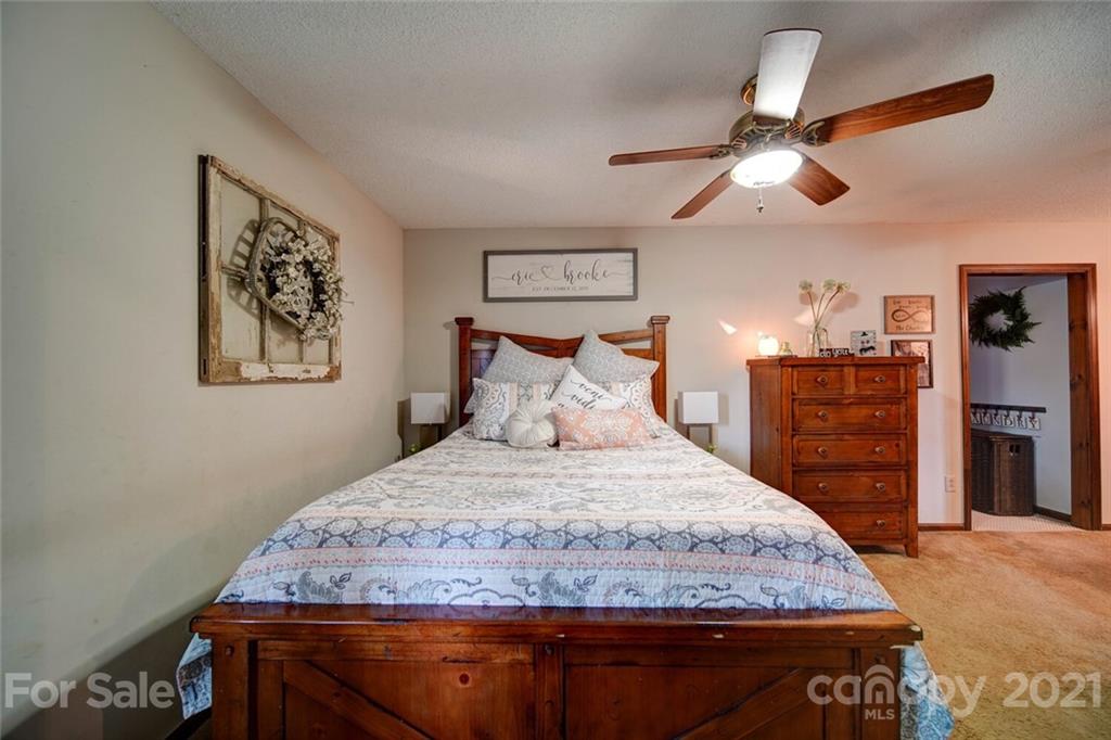 411 Gulledge Parker Road Monroe, NC 28112 - Photo 16 of 29 a bedroom with a bed and a chandelier