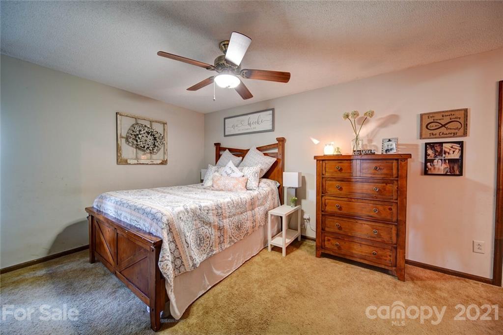 411 Gulledge Parker Road Monroe, NC 28112 - Photo 17 of 29 a bedroom with a bed and a chandelier