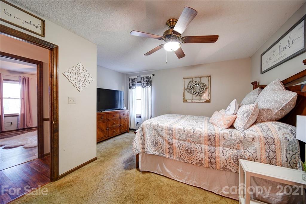 411 Gulledge Parker Road Monroe, NC 28112 - Photo 18 of 29 a bedroom with a large bed and a chandelier
