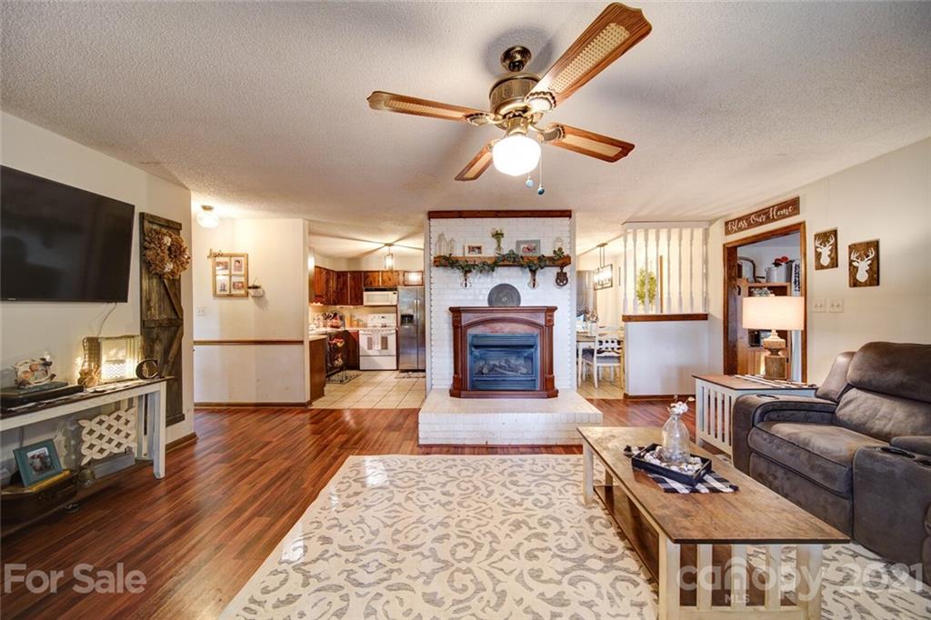 411 Gulledge Parker Road Monroe, NC 28112 - Photo 5 of 29 a living room with furniture a flat screen tv and a fireplace