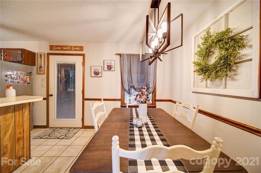 411 Gulledge Parker Road Monroe, NC 28112 - Photo 6 of 29 a dining room with wooden floor and a chandelier