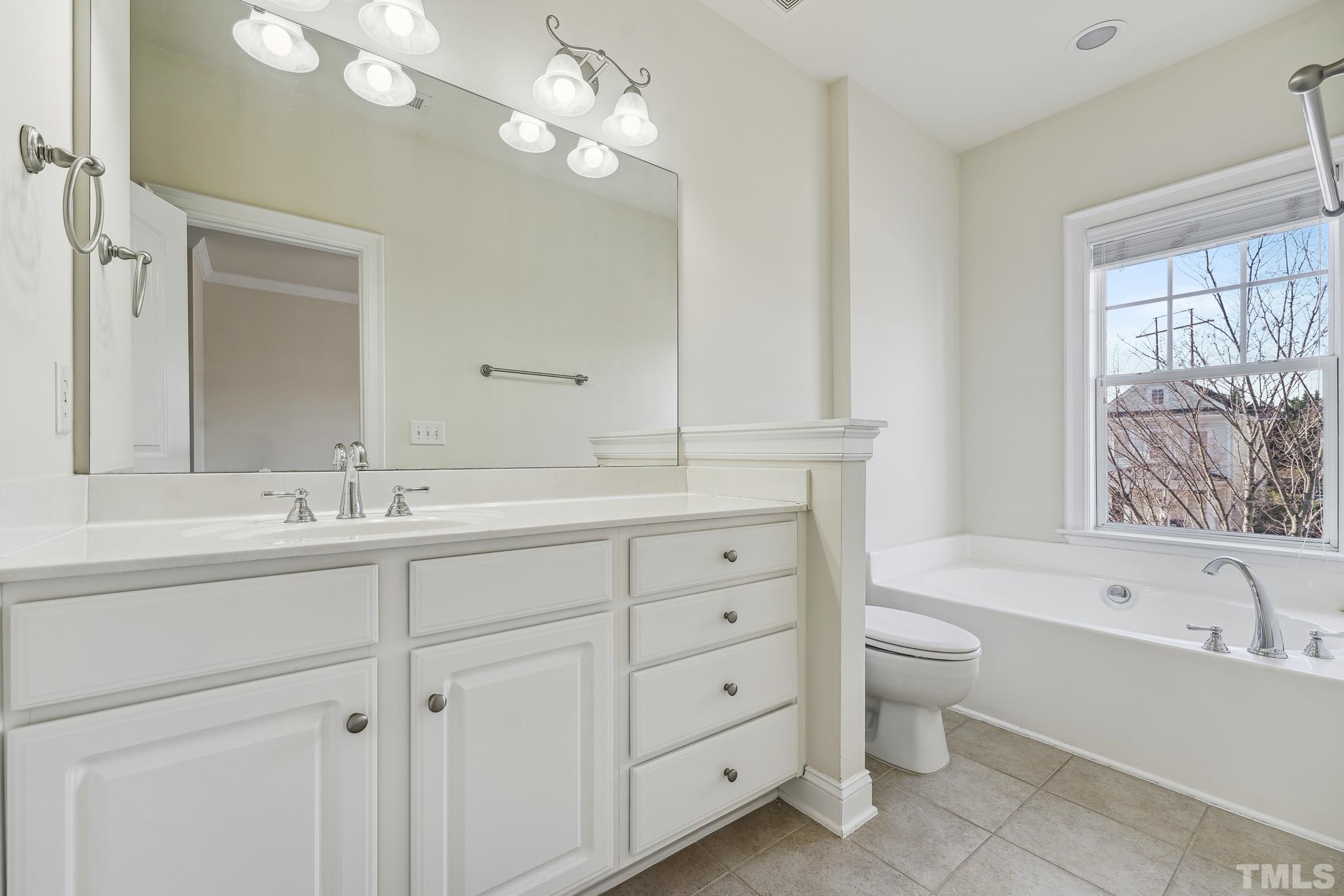 7710 ACC Boulevard Raleigh, NC 27617 - Photo 21 of 33 a bathroom with a double vanity sink a mirror and a bathtub
