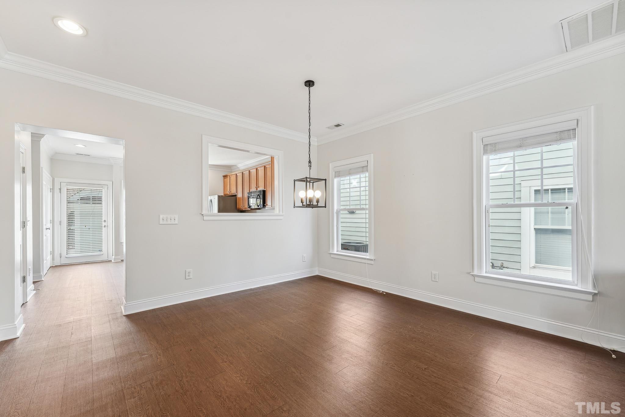 7710 ACC Boulevard Raleigh, NC 27617 - Photo 9 of 33 an empty room with wooden floor and windows