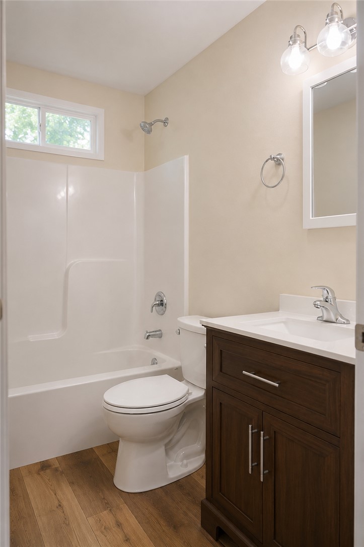 605 Hampton Street Iva, SC 29655 - Photo 11 of 16 Functional bathroom featuring a tub-shower combination, a vanity with a white countertop, and durable wood-look flooring.