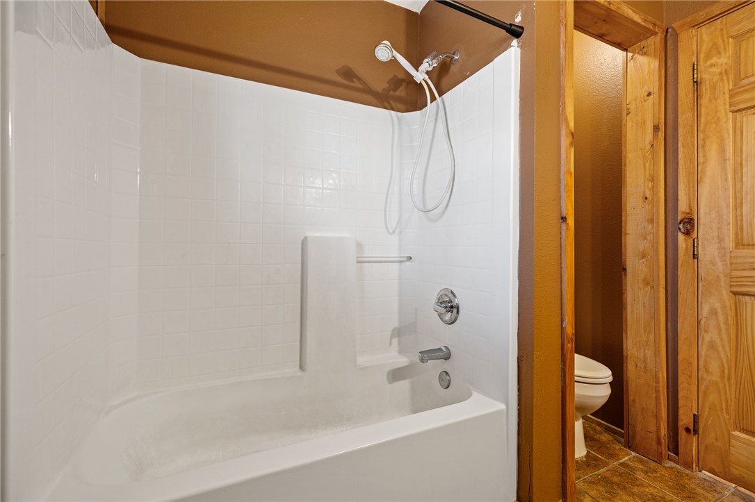 10557 North Devils Den Road Winslow, AR 72959 - Photo 28 of 60 Bathroom with shower / bath combination and dark tile patterned flooring