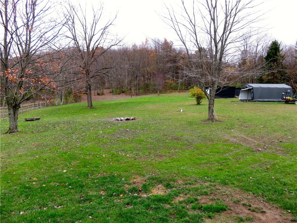 294 Sportsmen Road Hunker, PA 15639 - Photo 15 of 19 Property goes through woods to over top of hill. Covered carport and shed on the right.