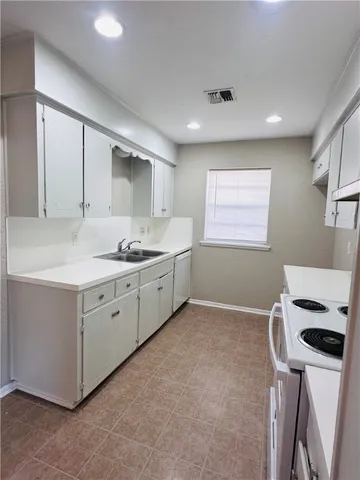 a kitchen with a sink cabinets and window