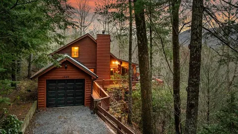 an aerial view of a house with balcony and trees al around