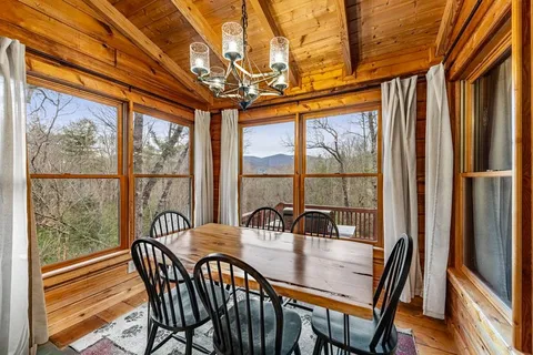 a dining room with furniture a chandelier and wooden floor