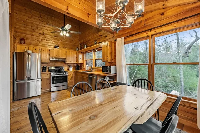 a view of a dining room with furniture large window and kitchen view